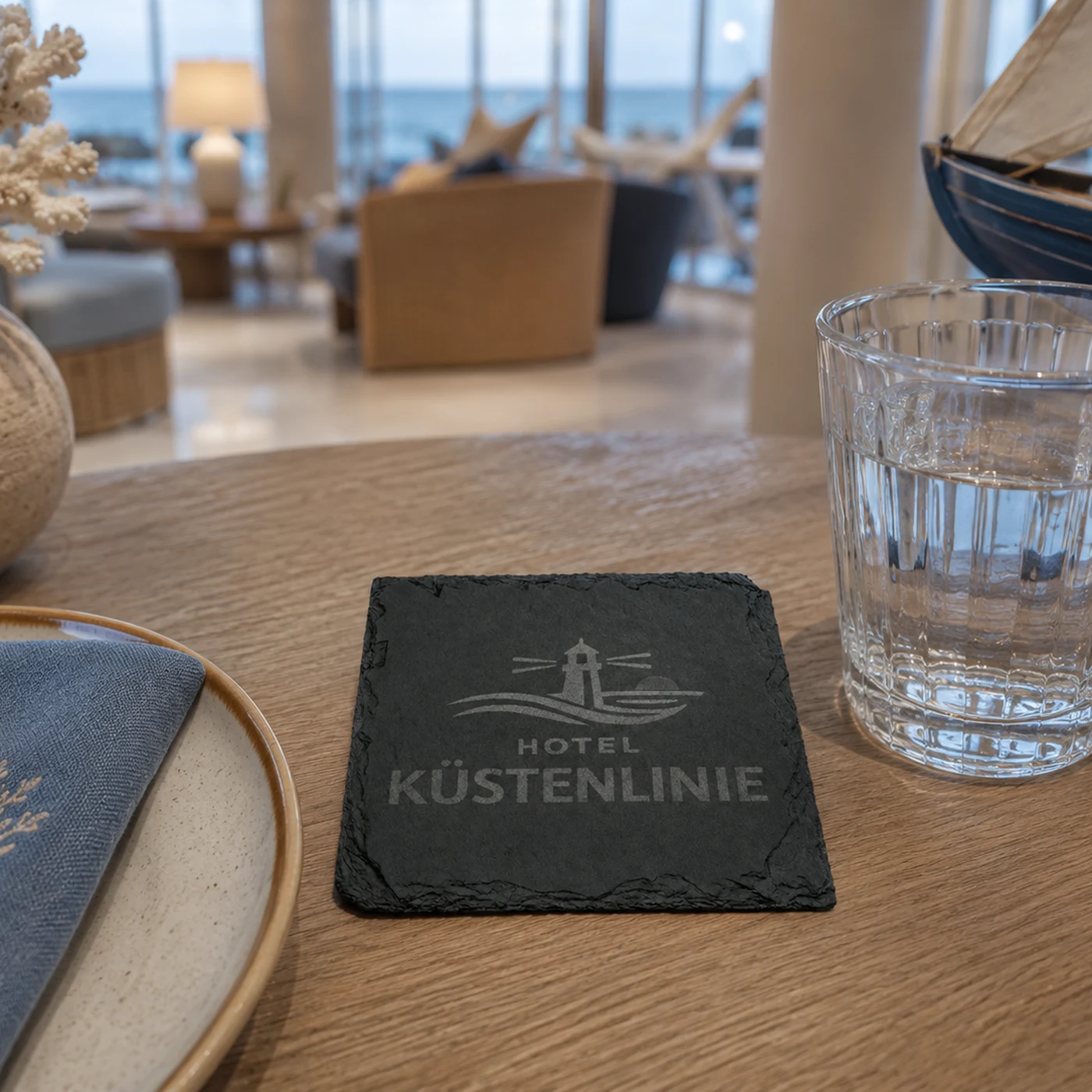 Schiefer Untersetzer mit lasergraviertem Firmenlogo auf einem Gastronomietisch neben einem Glas – Bild 7 von 8